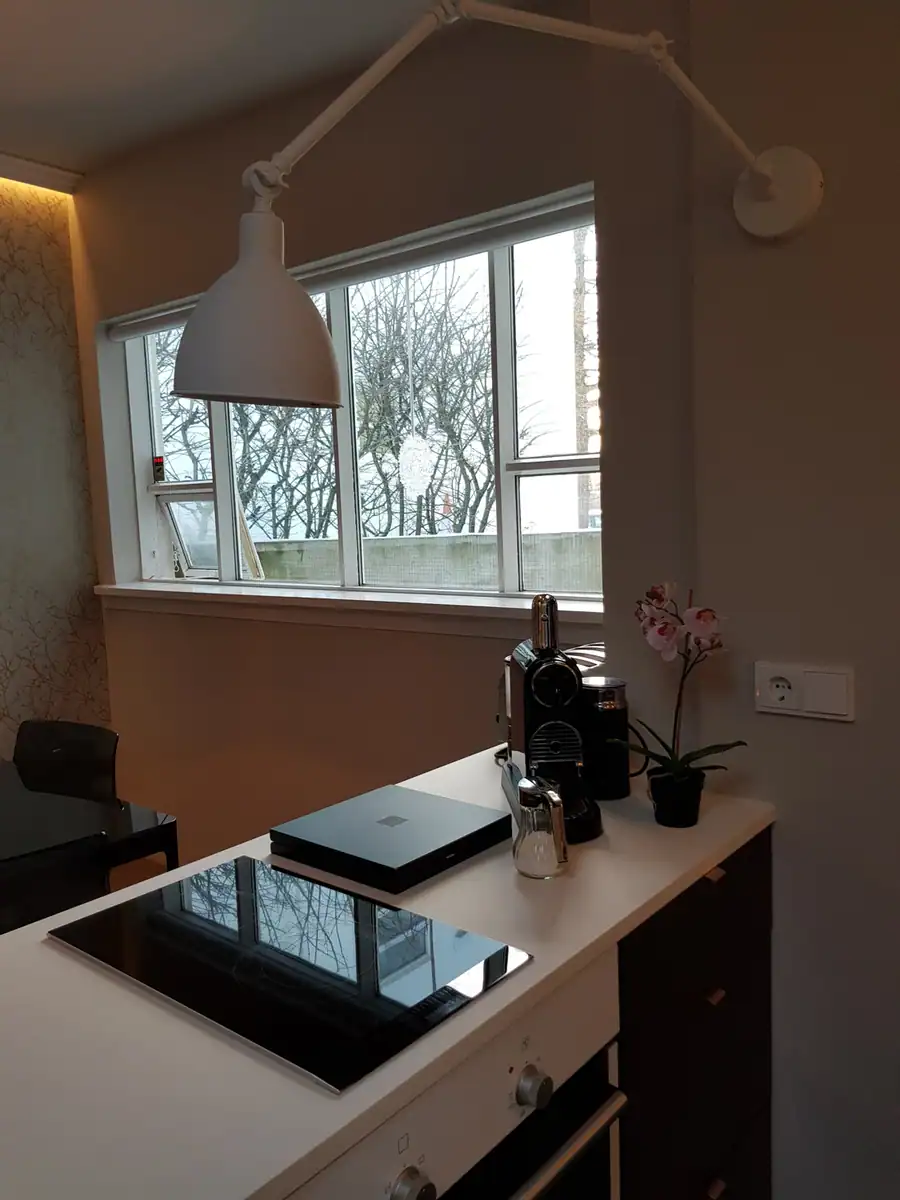 Eldhúskrókur með vegglampa og útsýni út um gluggann
