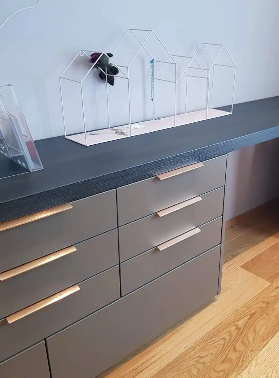 Lágskápur með dökkri borðplötu og ljósum handföngum